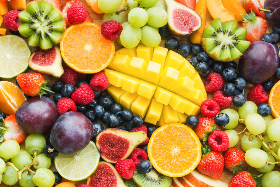 Verschiedene Früchte, einige davon aufgeschnitten, z.B. Ananas, Orangen, Feigen, Himbeeren, Kiwis. Borsäure kommt in fast allen Früchten natürlich vor.