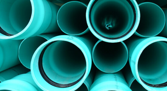Mint farbene PVC Rohre (Polyvinylchlorid) gestapelt von vorn, so dass man in die Rohre hinein schauen kann.