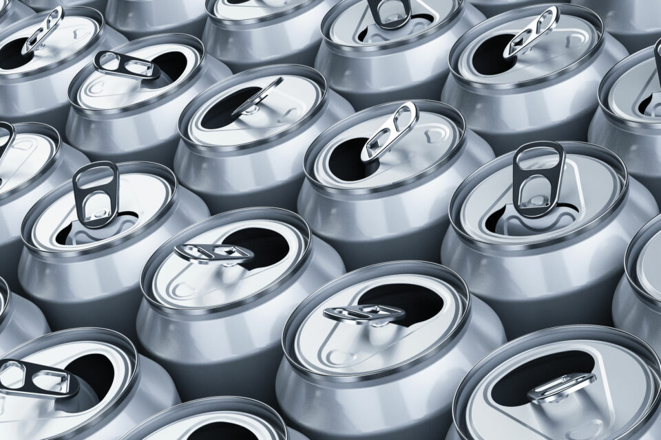 Mehrere bereits geöffnete Getränkedosen aus Aluminium stehen nebeneinander